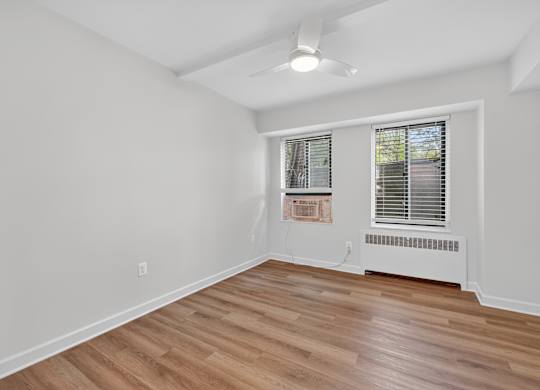 A room with a window and a fan on the ceiling.