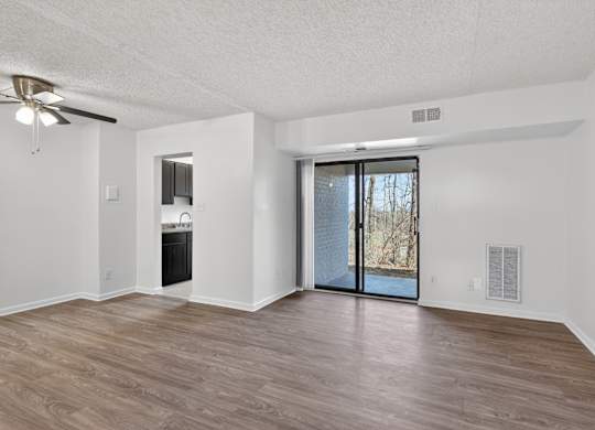 A room with a sliding glass door leading to a backyard.