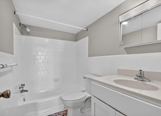 A white bathroom with a sink, toilet and bathtub.