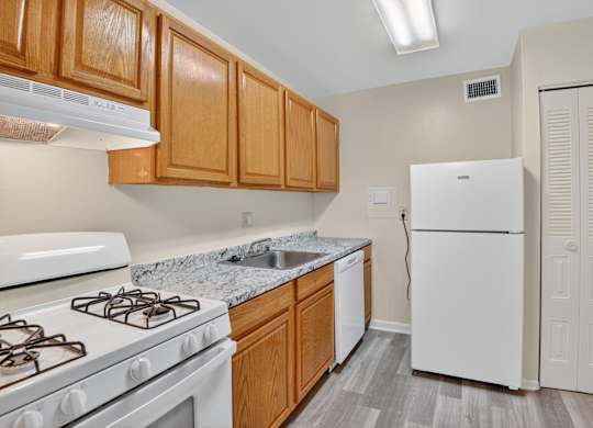 A kitchen with a white stove and wooden cabinets.