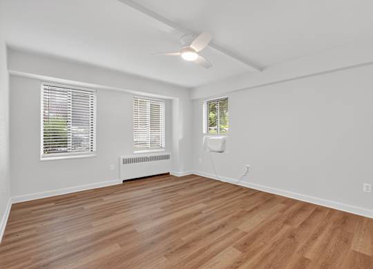A room with wooden flooring and white walls.