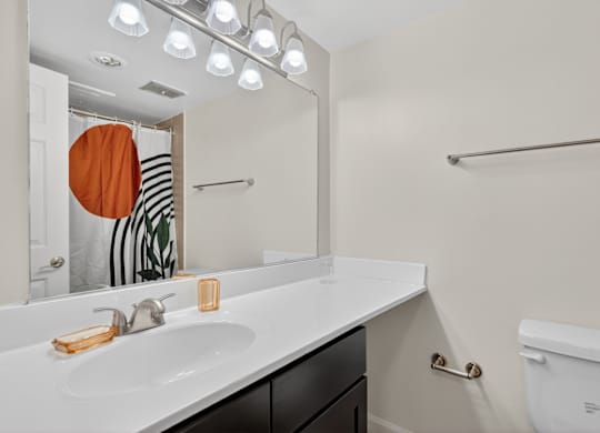 A bathroom with a white sink and a white toilet.