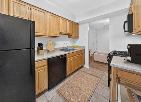 A kitchen with black appliances and wooden cabinets.