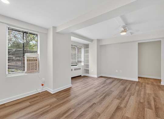 A room with wooden flooring and a ceiling fan.
