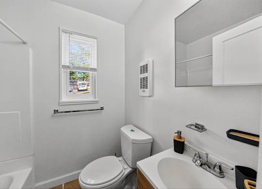 A white toilet sits next to a sink in a small bathroom.