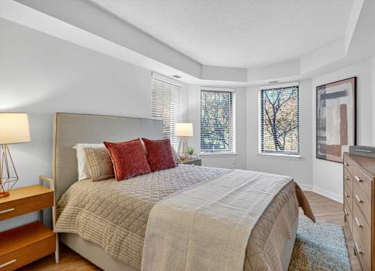 A bedroom with a large bed and a wooden dresser.