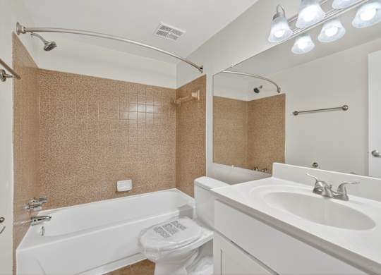 A white bathroom with a toilet, sink, and bathtub.