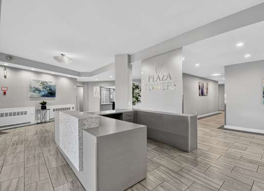 A modern office space with a reception desk and a large painting on the wall.