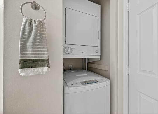 A white washing machine is in a small laundry room.