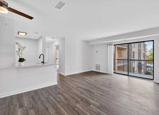 A spacious room with a ceiling fan and sliding glass doors.