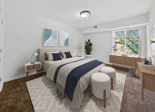 A bedroom with a large bed and a window overlooking trees.