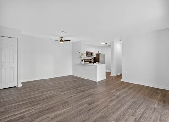 A room with wooden floors and a ceiling fan.