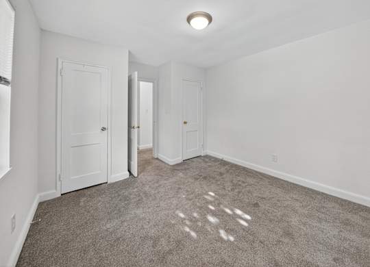 A room with carpeted floor and white walls.