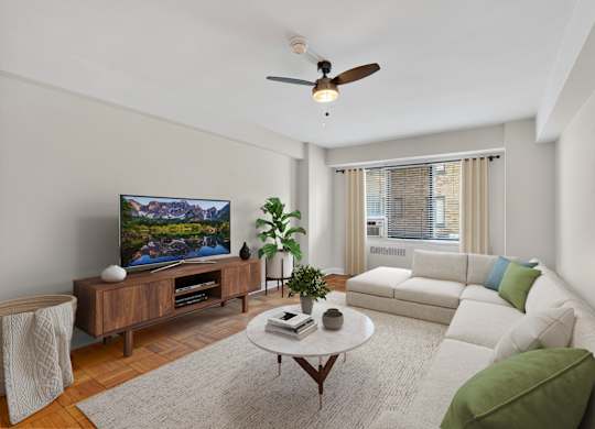 A living room with a flat screen TV, a white couch, and a coffee table.