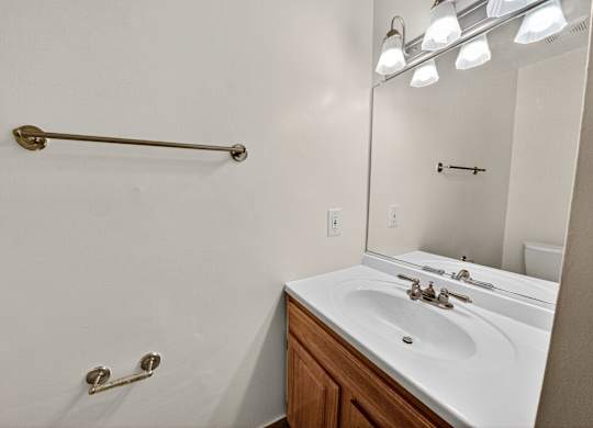 A bathroom with a white sink and a white towel rack.