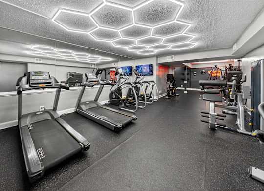 A gym with treadmills, exercise bikes, and other equipment.