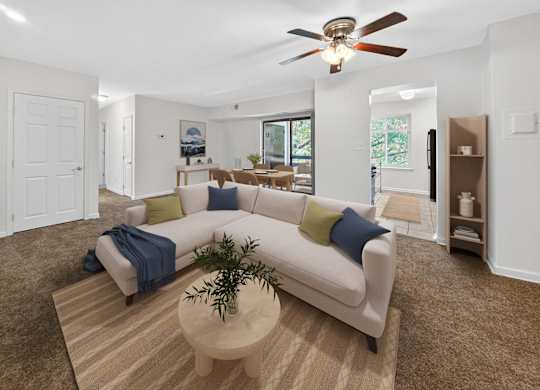 A living room with a white couch and a ceiling fan.