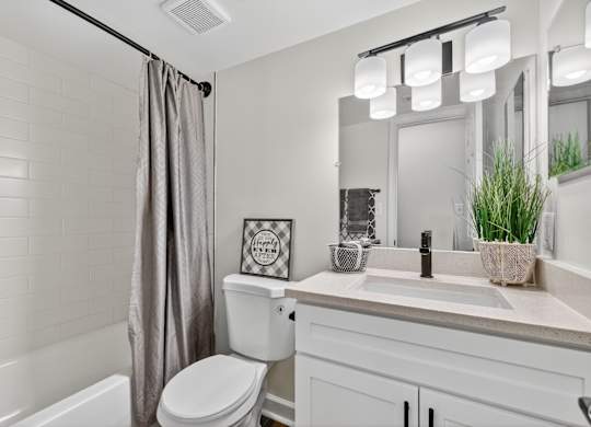 A white bathroom with a toilet, sink, and a mirror.