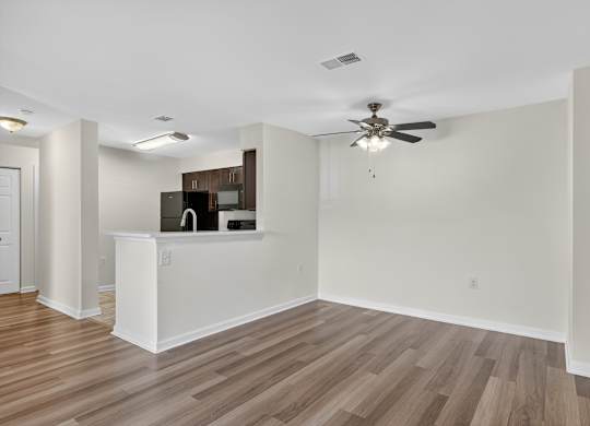 A room with a ceiling fan and a white counter.