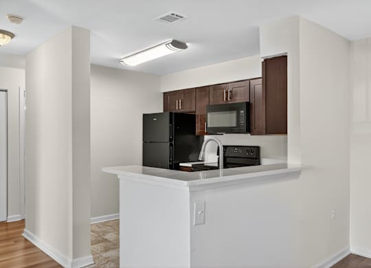 A kitchen with white cabinets and appliances.