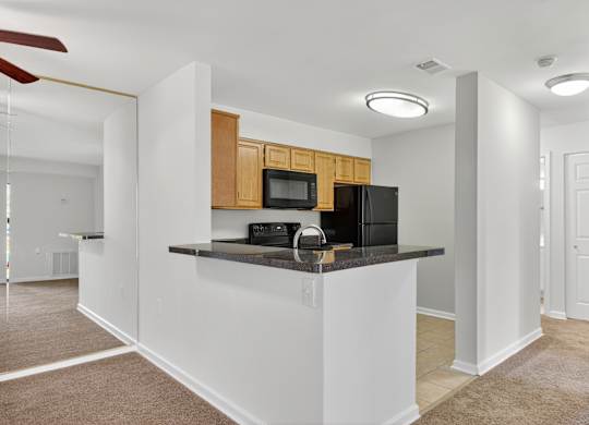 A kitchen with a white counter and brown cabinets.