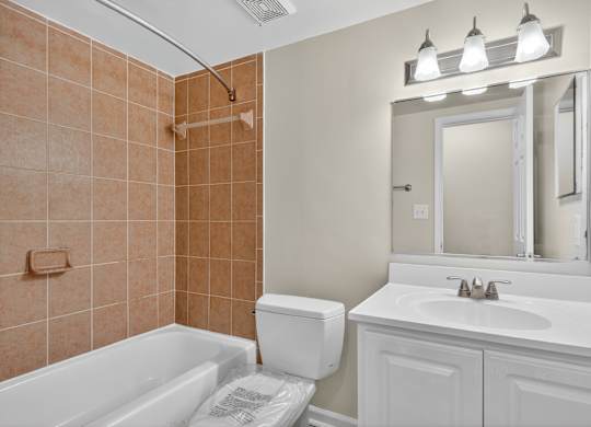 A bathroom with a white tub, sink, and toilet.