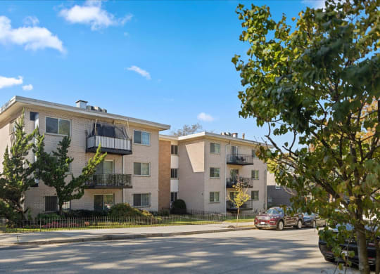 a street view of an apartment building with a car parked in front