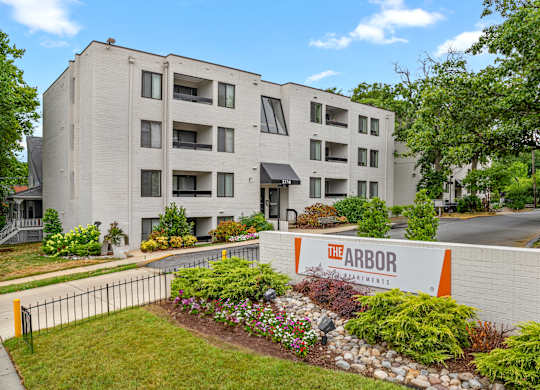 an exterior view of the apartment building with a sign in front of it