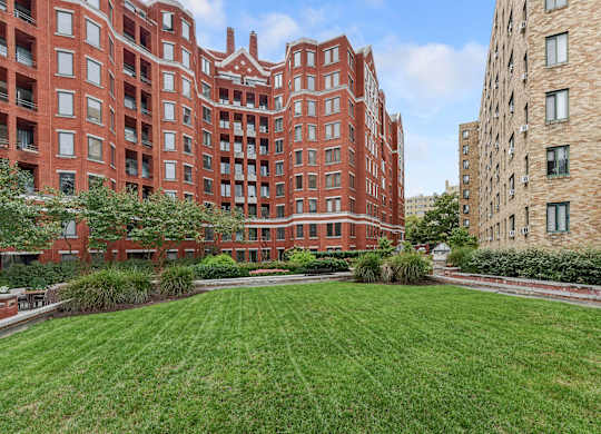 A red brick building with a green lawn in front.