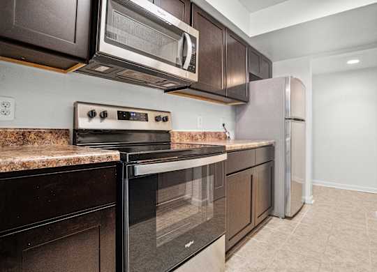 a kitchen with stainless steel appliances and dark wood cabinets