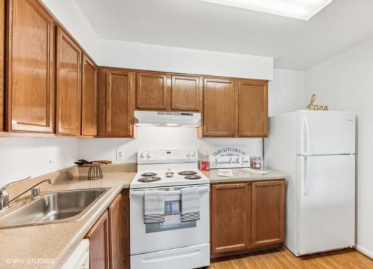 a kitchen with wooden cabinets and appliances and a white refrigerator on Benning Rd