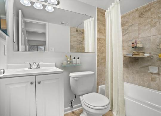 a white bathroom with a shower toilet and sink