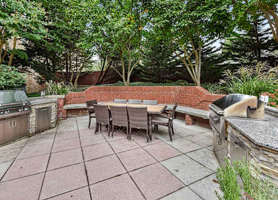 A patio with a table and chairs surrounded by trees.