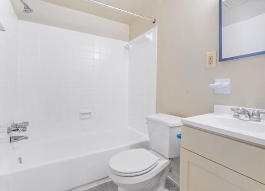 A white toilet sits next to a white sink in a bathroom.