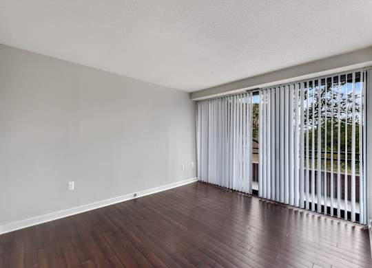 A room with a white door and a window with white blinds.