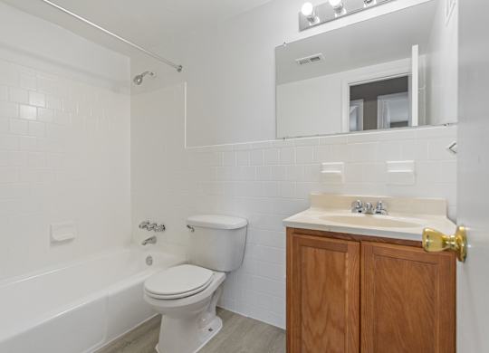 A white bathroom with a toilet, sink, and tub.