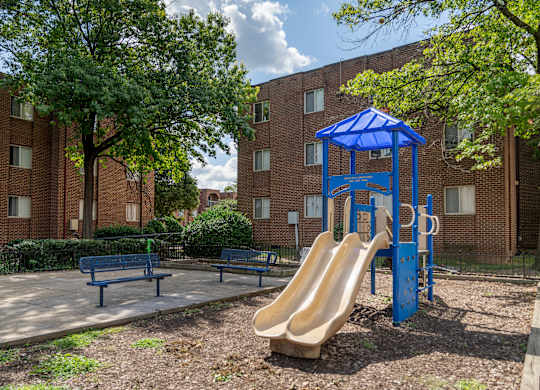 A playground with a blue slide and a blue canopy.
