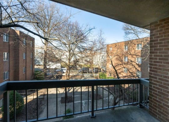 a balcony with a black railing and a brick building