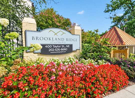 A sign for Brookland Ridge Apartments is surrounded by flowers.