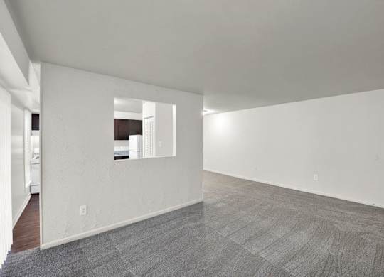 a large empty room with white walls and a tile floor