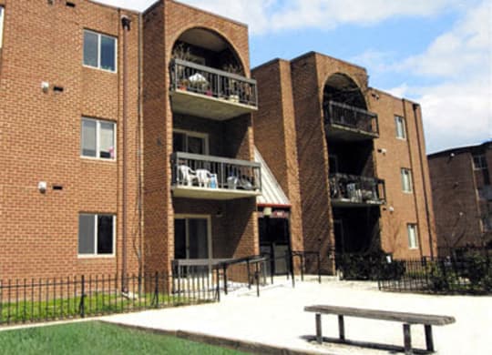 Exterior of Pentacle a large brick building with a picnic table in front of it