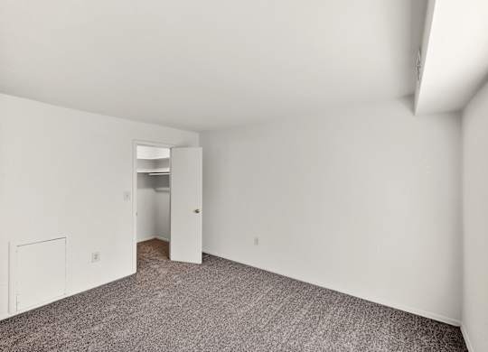 A room with white walls and carpeted floor.