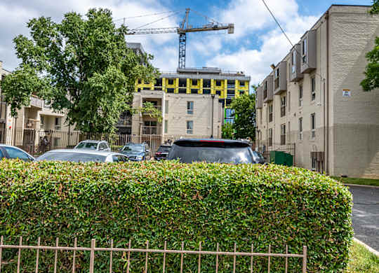 a construction site on a city street with cars and a fence