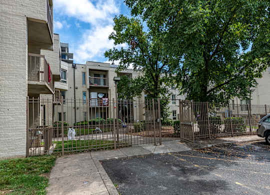 the yard of an apartment building with a yard behind a fence