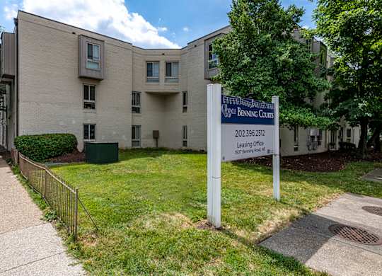 an apartment building with a sign in front of it