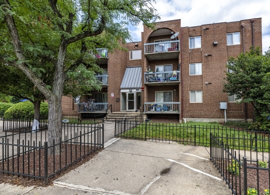 an apartment building with a yard and a wrought iron fence