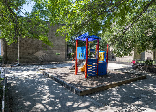 a playground with a blue and red swing set
