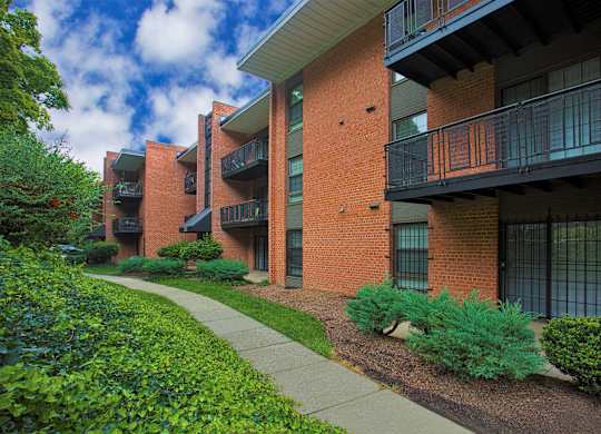 an apartment building with a sidewalk in front of it
