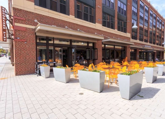 the outside of a Brookland Pint with yellow chairs and tables at Brookland Ridge Apartments, Washington, 20017