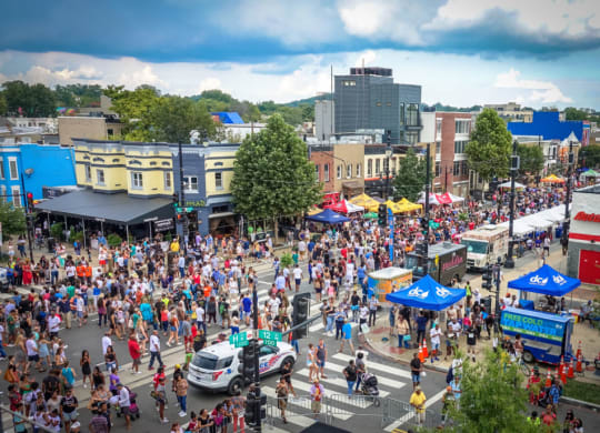 a crowd of people at a street festival in a city